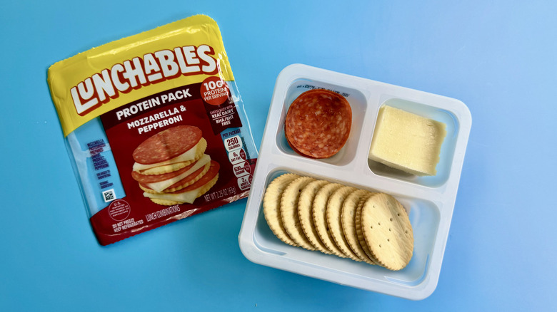 Mozzarella and Pepperoni Protein Pack with the package opened on a blue surface