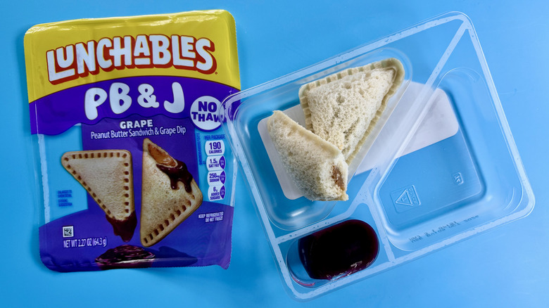 PB&J Peanut Butter Sandwich with Grape Dip, opened, on a blue surface