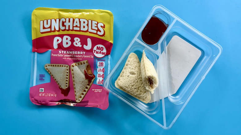 PB&J Peanut Butter Sandwich with Strawberry Dip in its opened packaging on a blue surface