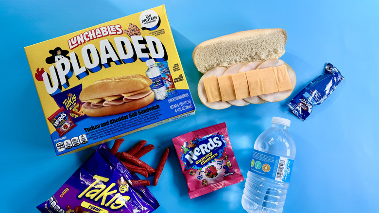 Uploaded Turkey and Cheddar Sub with all of the included accompaniments on a blue surface