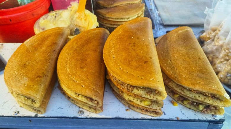 Several pieces of apam balik at a street food stall.