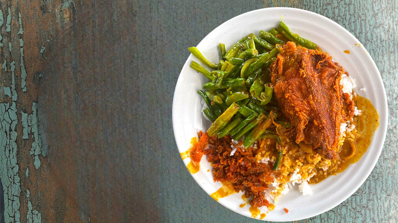 A plate of nasi kandar on a table.