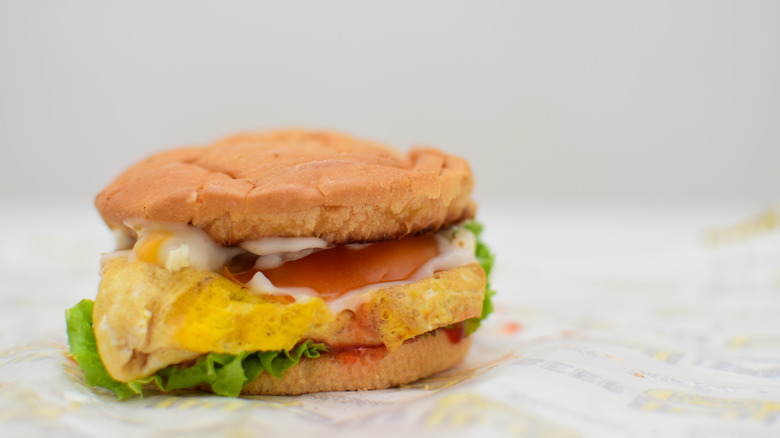 A Ramly burger on a wax paper wrapper.