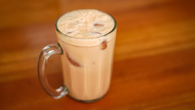 A glass of teh tarik on a table.