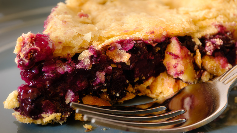 Closeup of blueberry pie with a fork next to it