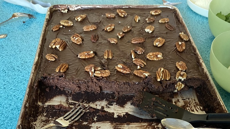 Texas sheet cake in a pan with pecans on top