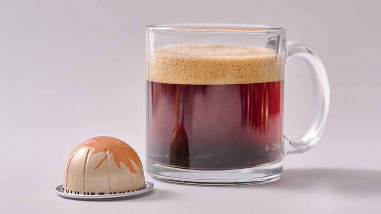 Maple Pecan Nespresso pod and glass of coffee on white table