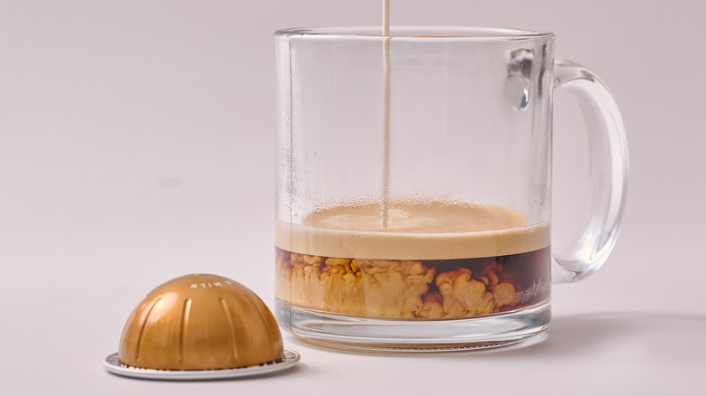 Bianco Doppio Nespresso pod and glass of coffee on white table