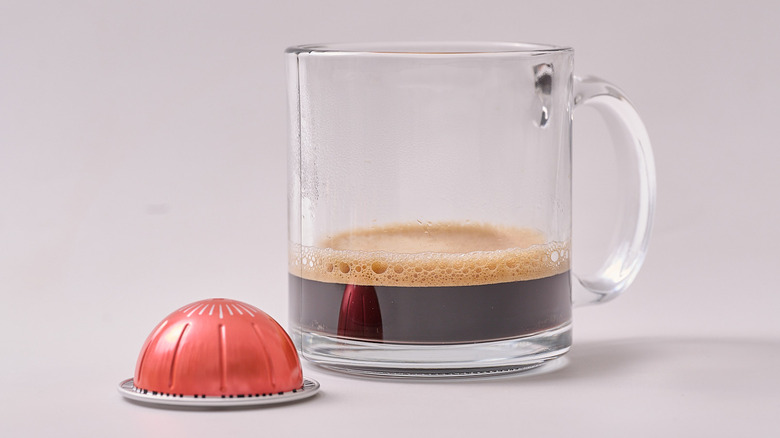 Ginseng Delight Nespresso pod and glass of coffee on white table