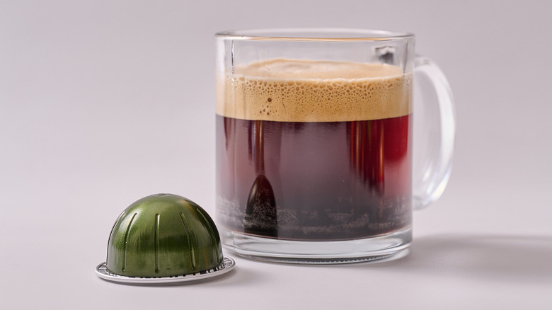 Stormio Nespresso pod and glass of coffee on white table
