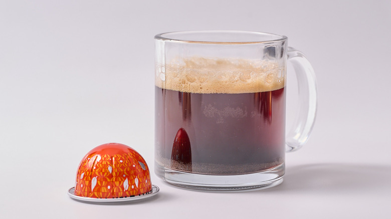 Pumpkin Spice Cake Nespresso pod and glass of coffee on white table