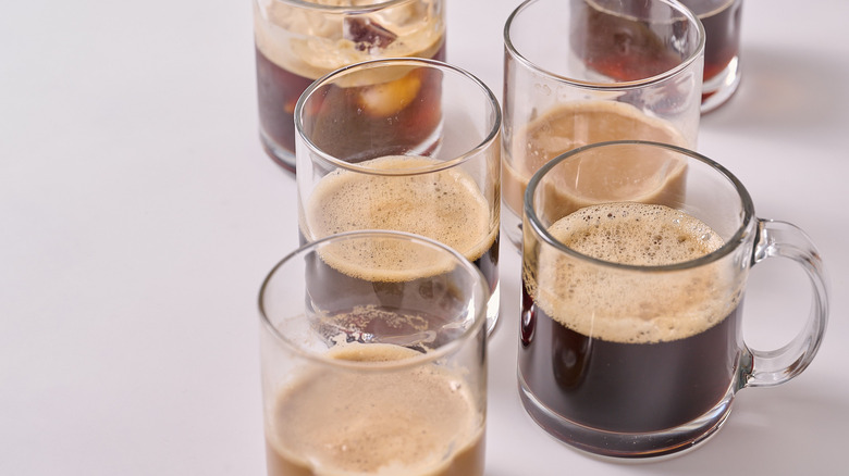 several glass cups of coffee on a table