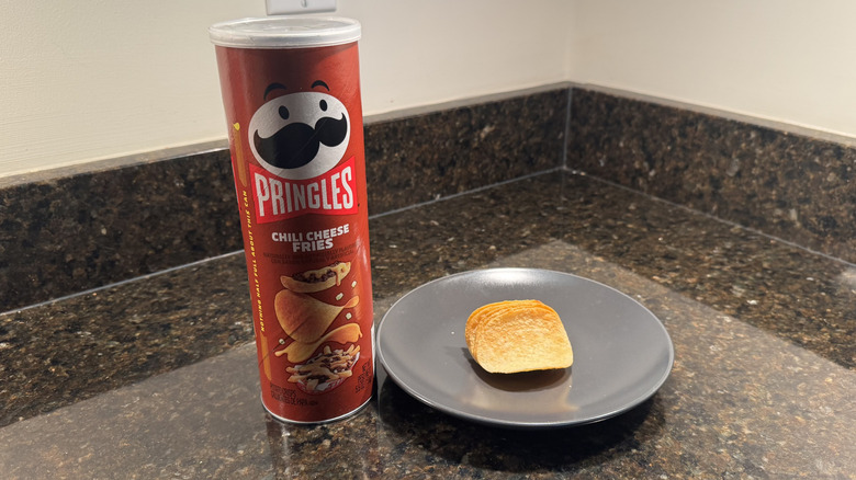 Pringles can on countertop with chips on a plate