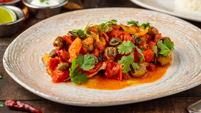 Snapper in red sauce and topped with olives