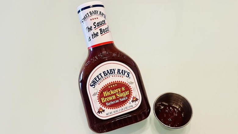 Bottle of Sweet Baby Ray's Hickory & Brown Sugar Barbecue Sauce with ramekin on side