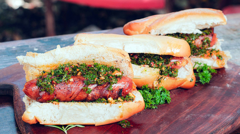 Three choripan sandwiches with chimichurri