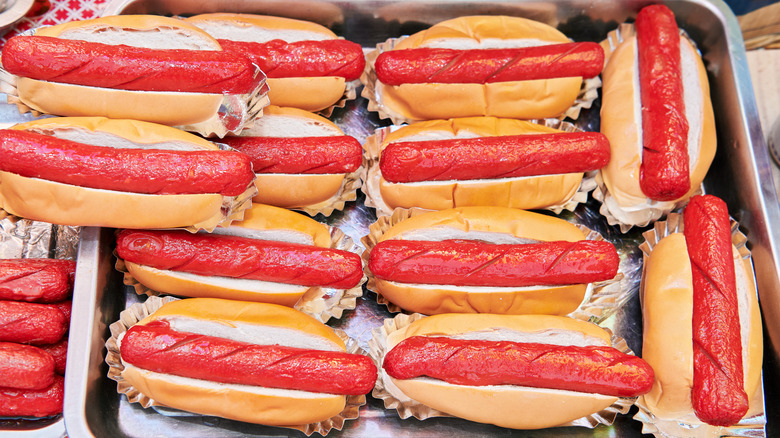 A tray of Filipino hot dogs in buns