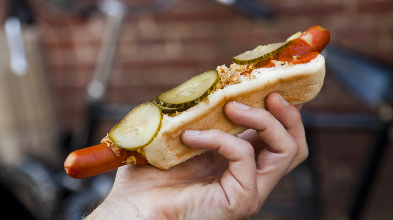 A person holding a ristet pølse