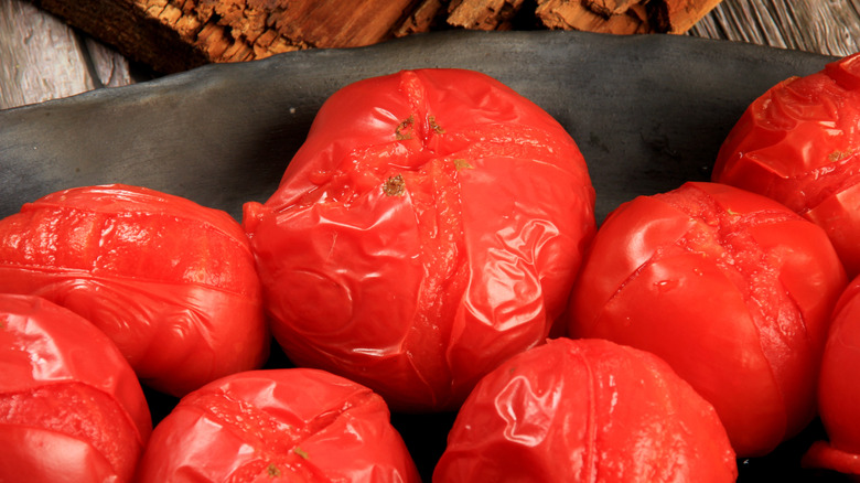 blanched tomatoes on black plate