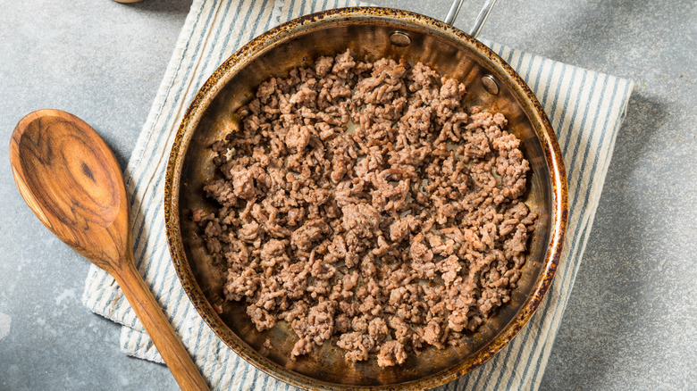 Ground beef in a pan with a spoon