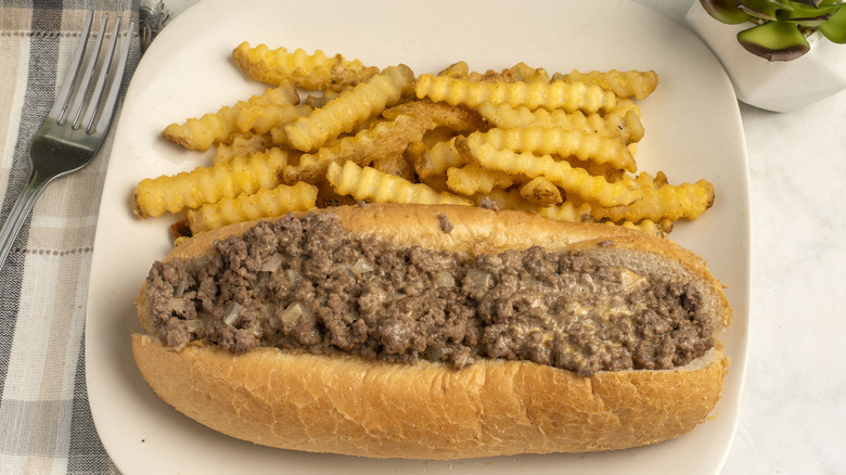 Chopped cheese sandwich with french fries on a plate