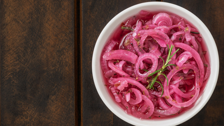 Bowl of pickled red onions on wooden surface