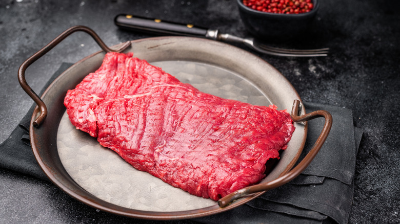 Raw flank steak on silver platter