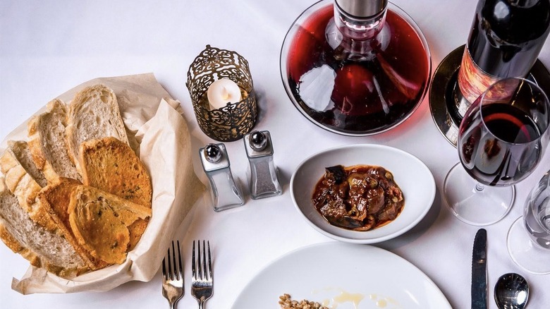 Bread, caponata, and red wine on a table at Andiamo Steakhouse