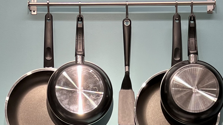 pots and pans hanging on blue wall