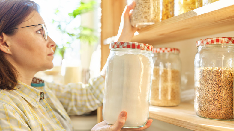 woman assessing ingredients in jars