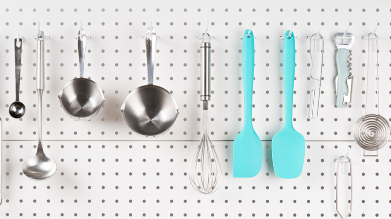 peg board with kitchen utensils