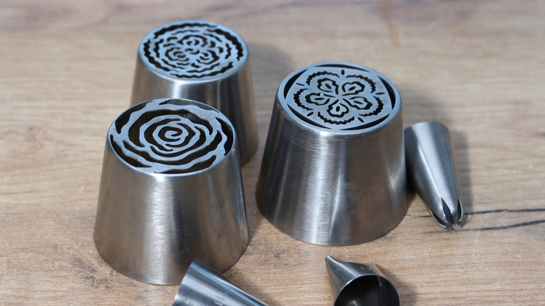 various metal pastry tips on wood background