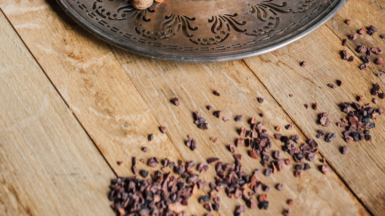 Almond Joy dirty soda in short glass sitting on fancy metal plate