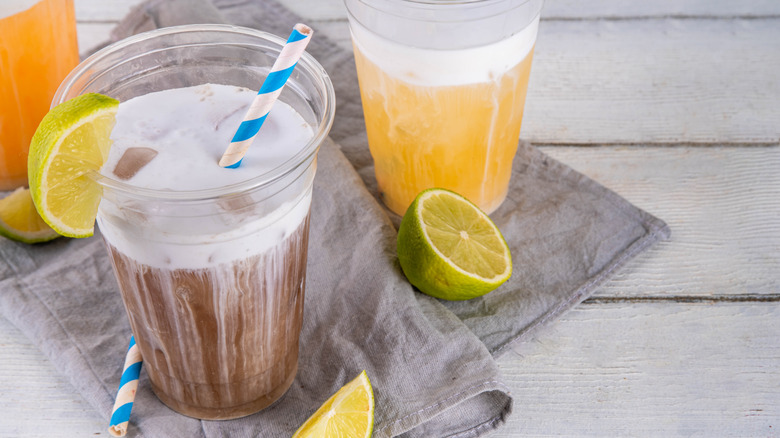Cold brew dirty soda in plastic cup garnished with a lime