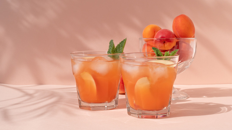 Peaches and Cream dirty soda in two glasses garnished with mint