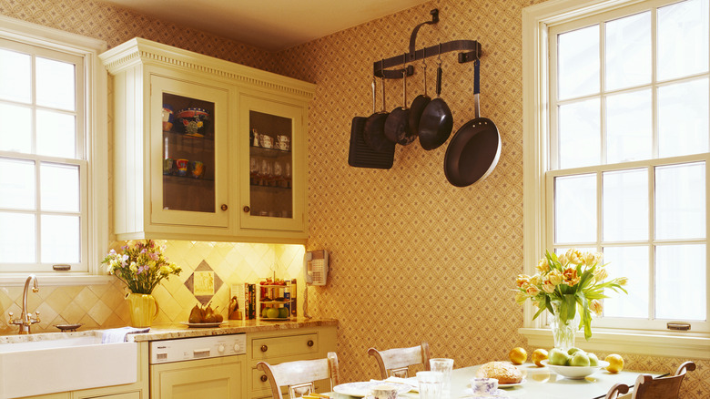 pot rack hanging from warm kitchen wall