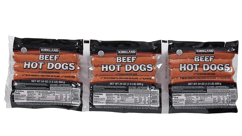 Three packages of Kirkland Signature Beef Hot Dogs on a white background