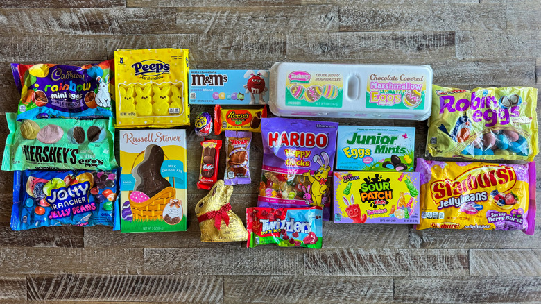 Multiple Easter candies in their packaging arranged on a brown wooden table