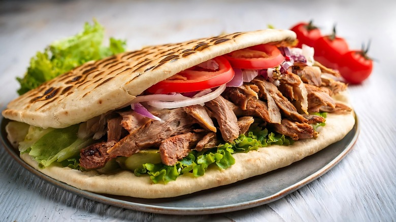 Meat on toasted pita bread with tomatoes