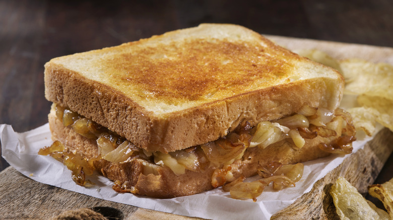 French onion grilled cheese sandwich on wooden board