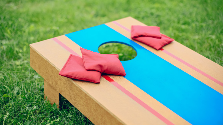 A cornhole game set up in a grassy yard