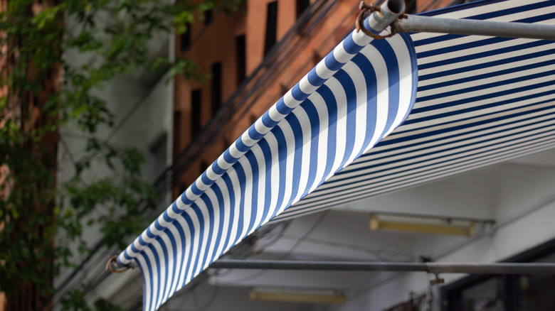A blue striped awning on a summery street