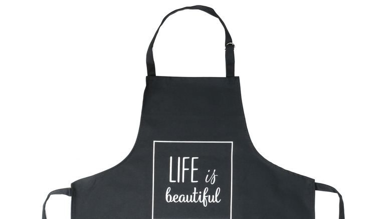 A black rubber apron on a white background