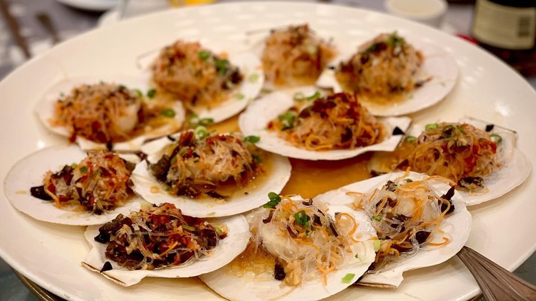A platter of scallops in their shell covered in toppings from Asian Jewels