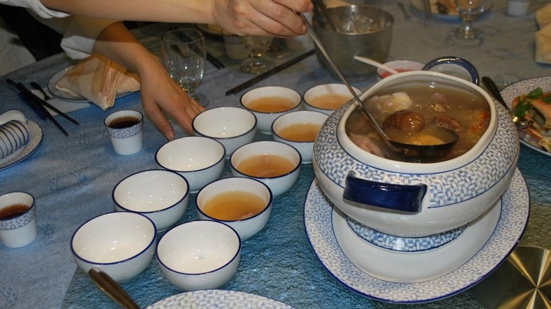 A person ladles soup from a large pot into many cups at Golden Lake Pavilion