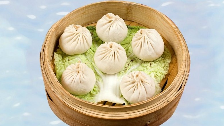 Steam buns laid on top of a cabbage leaf in a steam basket