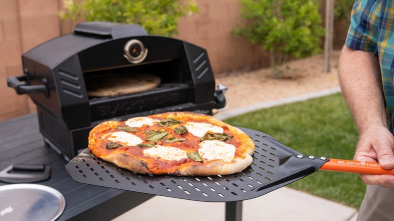 Pizza going into pizza oven