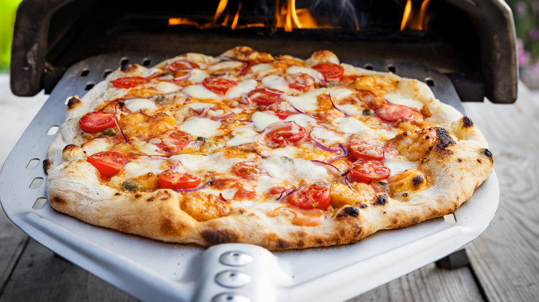 Delicious pizza going into pizza oven