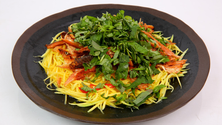 A plate of mango salad with smoked fish