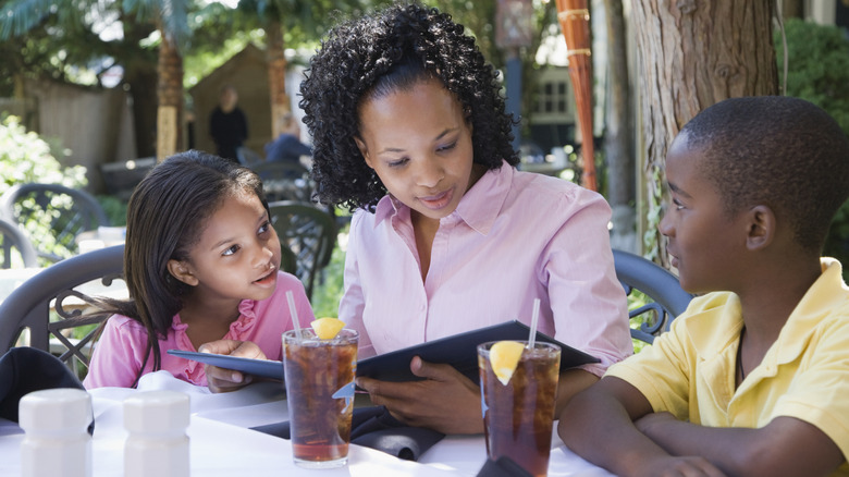 Person sitting at restaurant table with kids